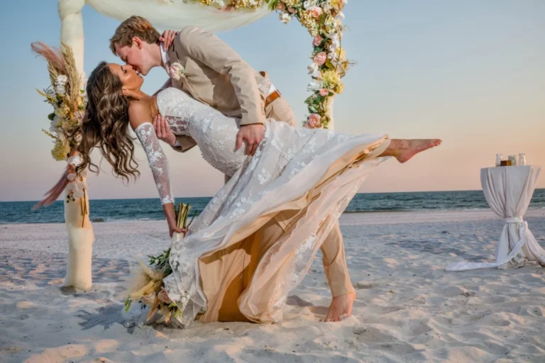 Gulf Shores Wedding Photographer Shooting with a Bride and Groom in front of a Bamboo Wedding Arch