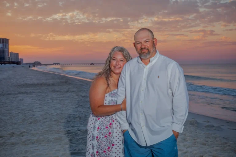 Bride and Groom with the beautiful orange sunset behind them from Gulf Shores Photographer.