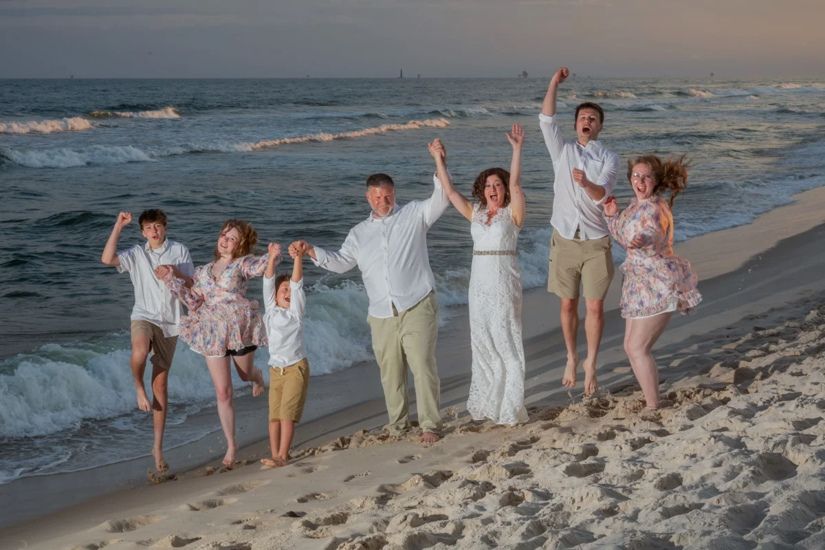 Happy wedding family having fun on the beach in Gulf Shores, Alabama. 