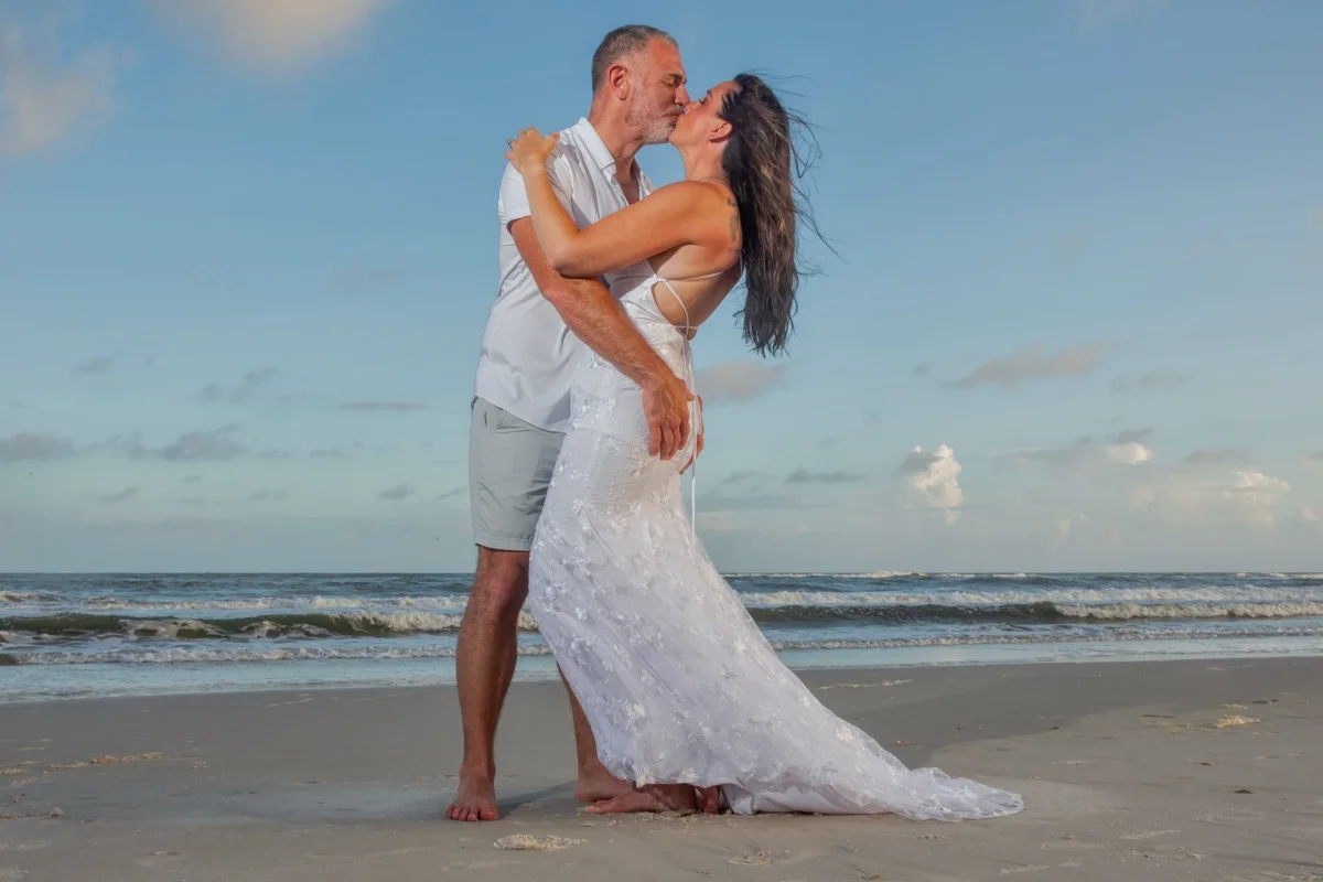 Bride and groom standing on the beach in a beautiful pose shot by a Gulf Shores photographer.