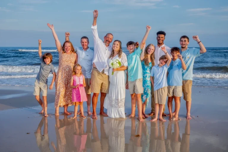 Wedding Party Standing on the Beach Having Fun shot by a gulf shores professional photographer.