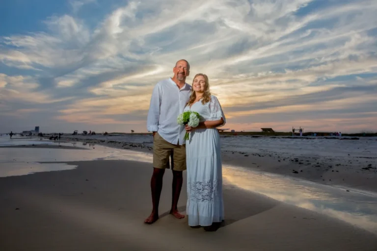 Gulf Shores Photography Bride and groom standing on the beach with a beautiful sunset.