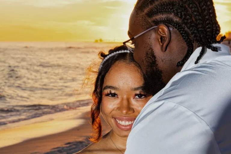 Groom kissing the bride's forehead in a beautiful sunset on the beach by Gulf Shores photographer.
